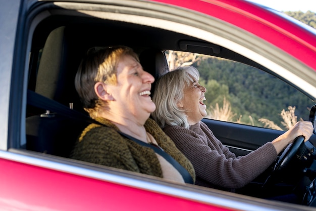 Zwei ältere frauen im auto fahren und unternehmen ein abenteuer in der natur