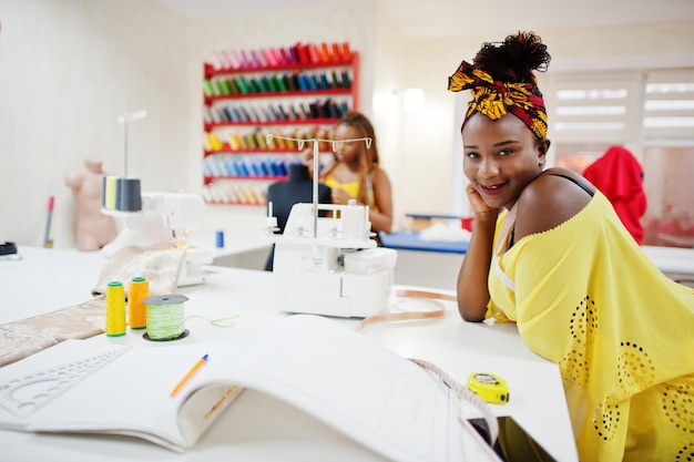 Zwei afrikanische Schneiderinnen näht Kleidung an der Nähmaschine im Schneiderbüro Schwarze Näherin Mädchen