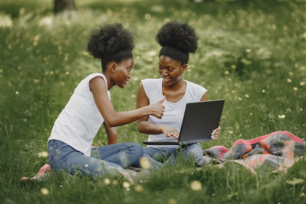 Zwei afroamerikanische Schwestern erholen sich in einem Park