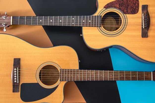 Zwei Akustikgitarren auf farbigem Hintergrund liegen flach