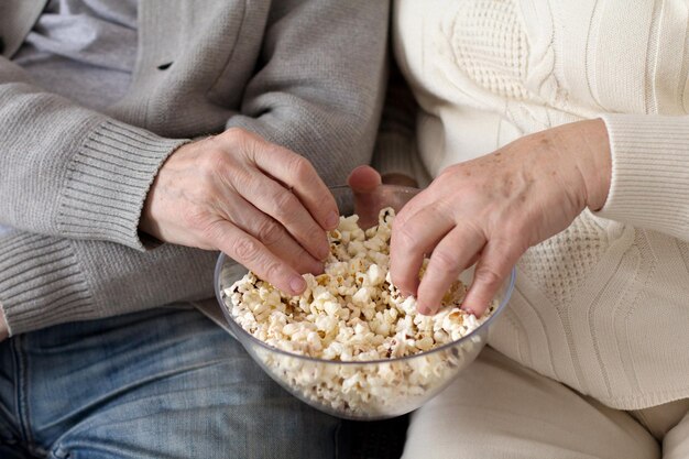 Zwei alte Leute essen zusammen Popcorn