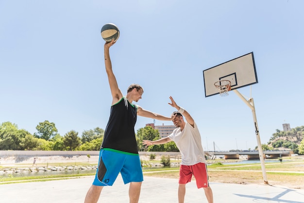 Zwei Basketball-Spieler, die draußen am Gericht üben