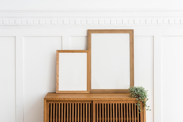 Zwei Bilderrahmen auf einem Holz-Sideboard