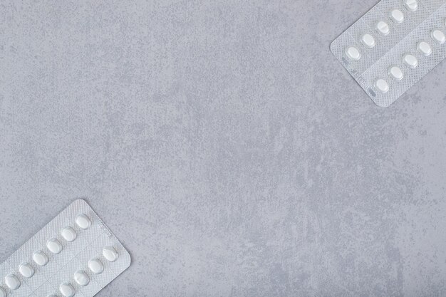 Zwei Blasen mit Pillen auf einem grauen Hintergrund.