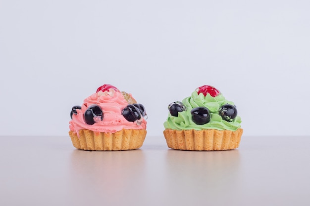 Zwei cremige Cupcakes auf Weiß.