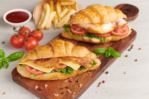 Zwei Croissant-Sandwiches auf Holztisch