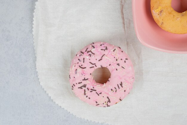 Zwei Donuts mit Sprinklern auf Marmortisch. Hochwertiges Foto