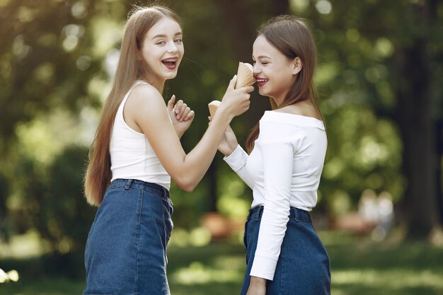 Zwei elegante und stilvolle Mädchen in einem Frühlingspark