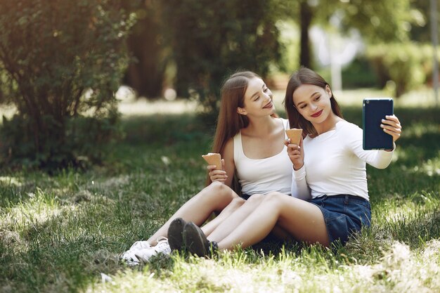 Zwei elegante und stilvolle Mädchen in einem Frühlingspark