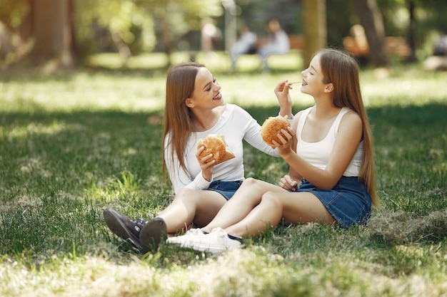 Zwei elegante und stilvolle Mädchen in einem Frühlingspark