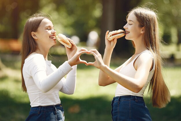 Zwei elegante und stilvolle Mädchen in einem Frühlingspark