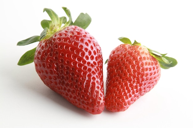 Zwei Erdbeeren auf einer weißen Fläche