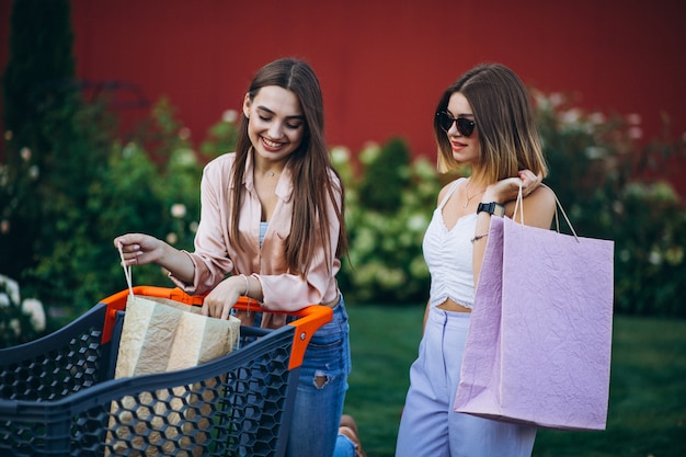 Zwei Frauen, die durch den Markt mit Einkaufswagen kaufen