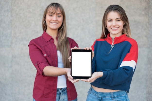 Kostenloses Foto zwei frauen, die tablettenmodell halten