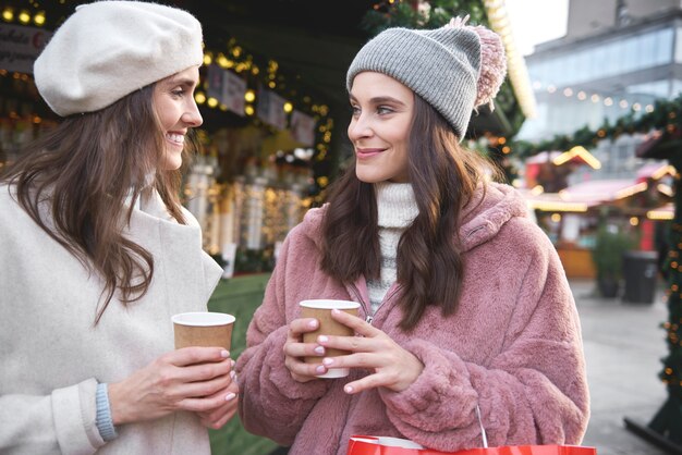 Zwei Freunde auf einem Weihnachtsmarkt trinken Glühwein