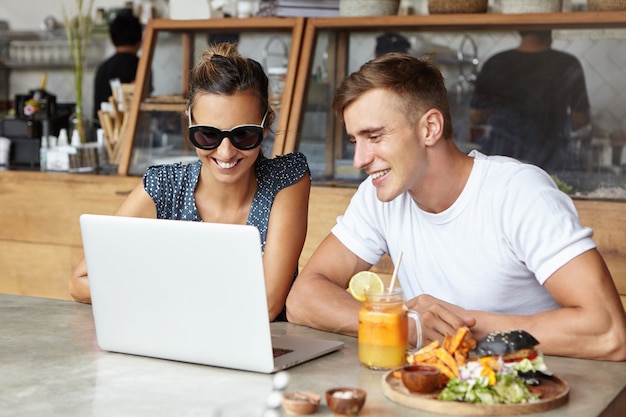 Zwei Freunde, die zusammen einen Laptop benutzen