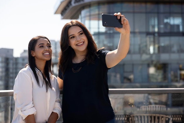 Zwei Freundinnen auf einer Dachterrasse machen ein Selfie