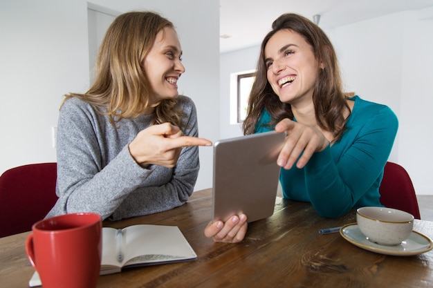 Zwei Freundinnen, die lustige Nachrichten besprechen