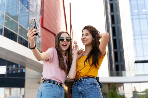 Zwei Freundinnen verbringen Zeit miteinander im Freien und machen Selfies