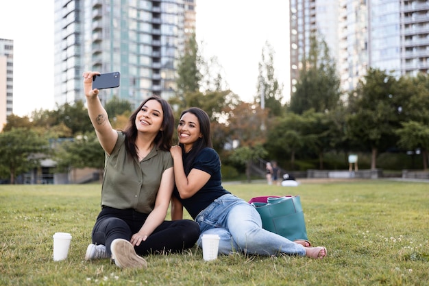 Zwei Freundinnen verbringen Zeit miteinander im Park und machen Selfies