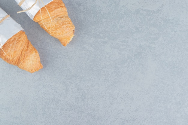Zwei geknotete Croissants auf dem Marmorhintergrund. Hochwertiges Foto