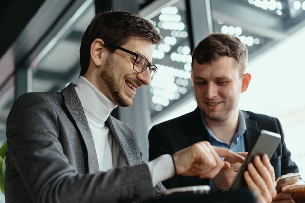 Zwei Geschäftsleute, die ein Gespräch mit einem Smartphone führen