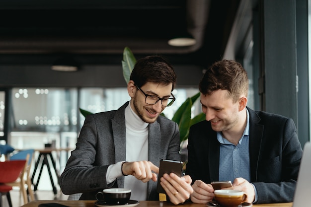 Zwei geschäftsleute, die ein gespräch mit einem smartphone führen