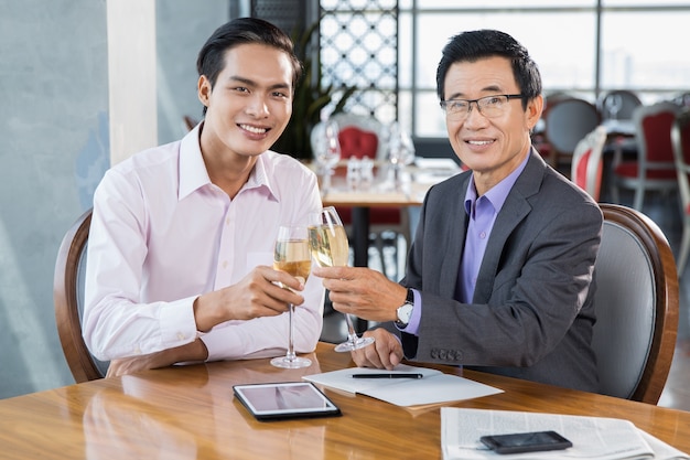Zwei Geschäftsleute feiern Erfolg im Restaurant