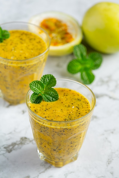 Zwei Gläser Passionsfruchtsaft auf weißen Marmorboden stellen