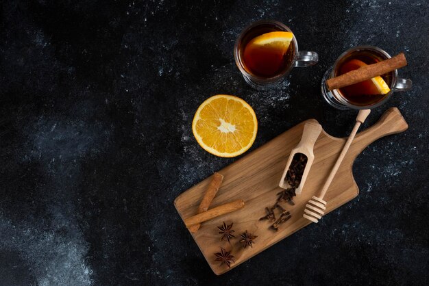 Zwei Glastassen Tee und mit Zimtstangen und Holzschöpflöffel.