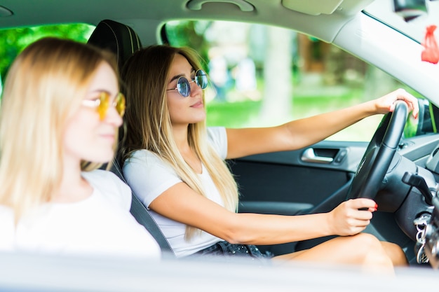 Zwei glückliche Freunde im Auto fahren überall hin und suchen Freiheit und Spaß