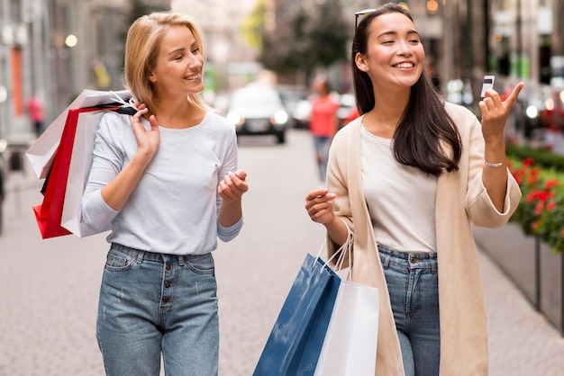 Zwei glückliche Freunde zum Einkaufen mit Einkaufstüten