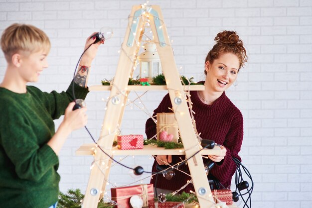 Zwei glückliche Mädchen, die den Weihnachtsbaum schmücken