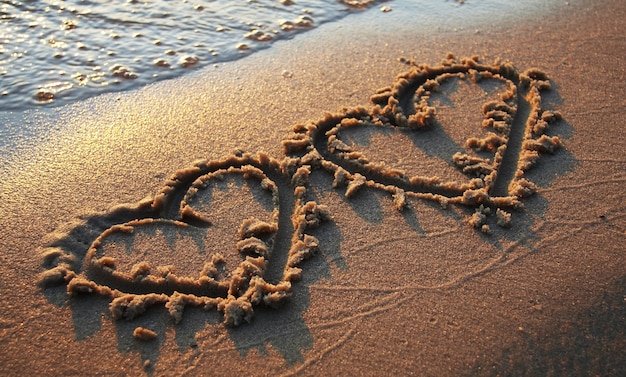 Zwei Herzen Formen Auf Sand Gezeichnet Kostenlose Foto