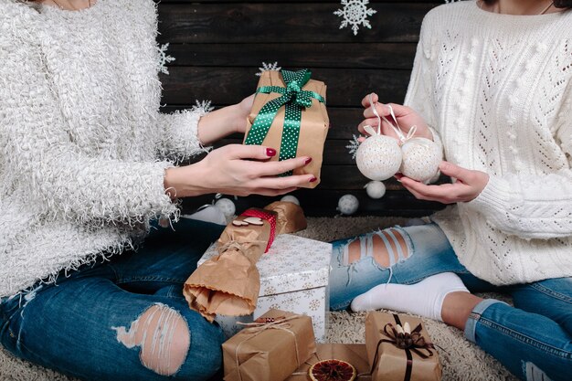 Zwei hübsche Frauen, die mit Geschenken für Weihnachten, Nahansicht aufwerfen