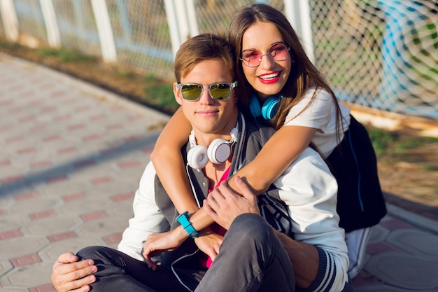 Zwei hübsche junge moderne Teenager, die draußen im stilvollen lässigen Outfit aufwerfen