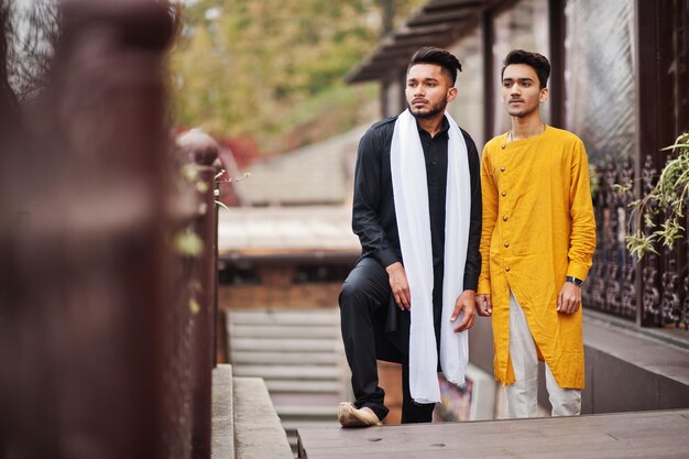 Zwei indische stilvolle Männerfreunde in traditioneller Kleidung posierten im Freien