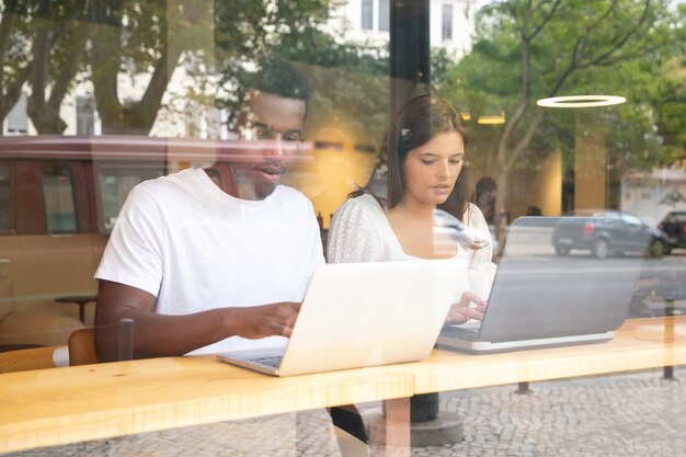 Zwei Inhaltsdesigner, die drinnen hinter dem Fenster arbeiten