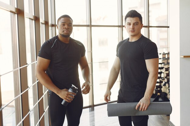 Zwei internationale Freunde sind in einem Fitnessstudio beschäftigt