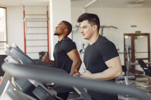 Zwei internationale Freunde sind in einem Fitnessstudio beschäftigt