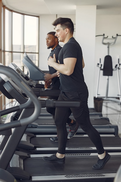 Zwei internationale Freunde sind in einem Fitnessstudio beschäftigt