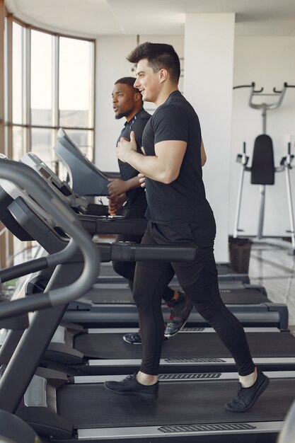 Zwei internationale Freunde sind in einem Fitnessstudio beschäftigt