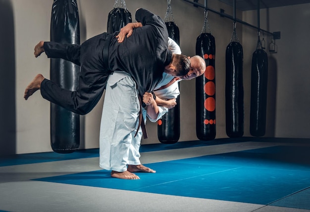 Kostenloses Foto zwei judo-wrestler zeigen ihre technischen fähigkeiten im fight club.