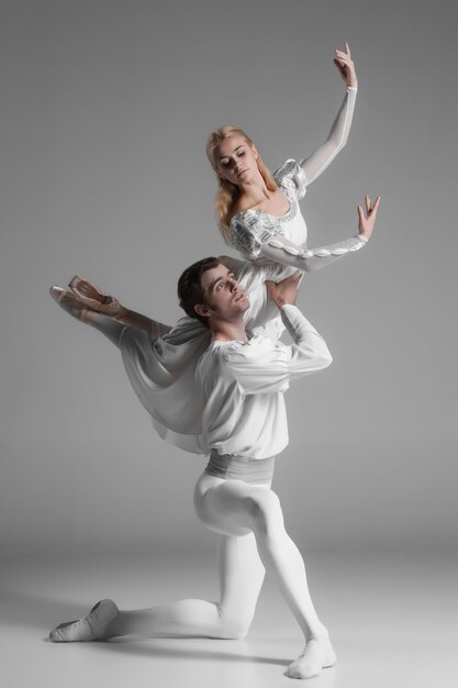 Zwei junge Balletttänzer üben. attraktive tanzende Darsteller in Weiß