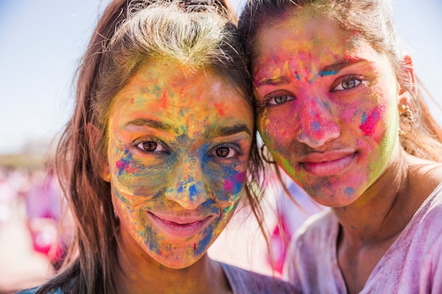 Zwei junge Frauen bedeckten ihr Gesicht mit Holi-Farbpulver