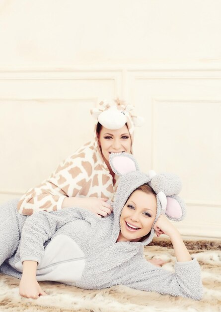 Zwei junge Frauen in einem Pyjama haben Spaß.