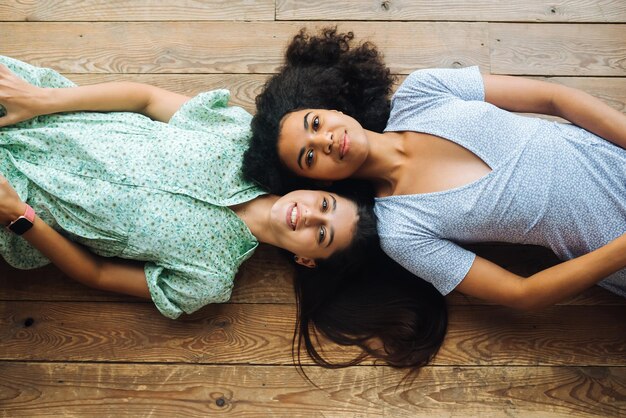 Zwei junge Frauen liegen Kopf an Kopf auf der Bodenansicht