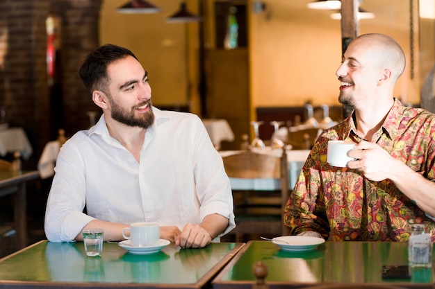 Zwei junge Freunde verbringen Zeit miteinander, während sie in einem Café eine Tasse Kaffee trinken.