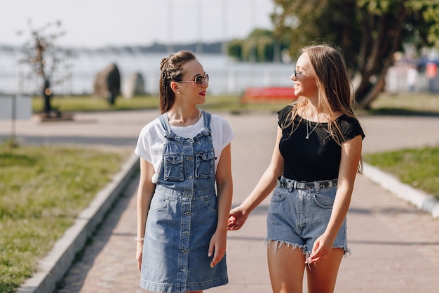 Zwei junge hübsche Mädchen auf einem Spaziergang im Park oder auf der Straße