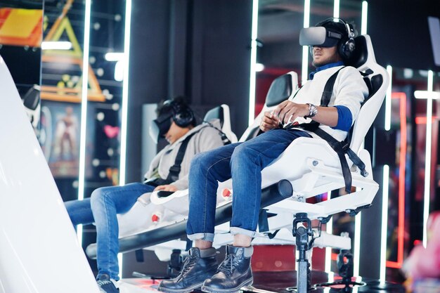 Zwei junge Inder, die Spaß mit einer neuen Technologie eines VR-Headsets am Virtual-Reality-Simulator haben